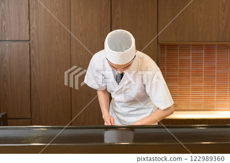 A Japanese chef cooking 122989360