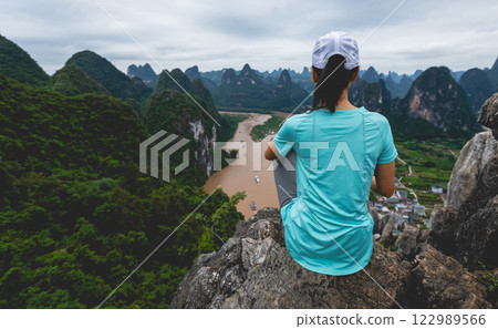 Woman tourist enjoy the beautiful landscape of yangshuo county, China Woman tourist enjoy the beautiful landscape of yangshuo county, China 122989566