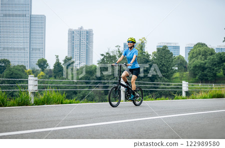 Riding a fold bike with modern city in the distrance 122989580