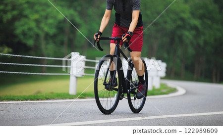 Asian woman cycling on summer trail Asian woman cycling on summer trail 122989609