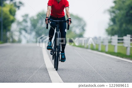Asian woman cycling on summer trail 122989611