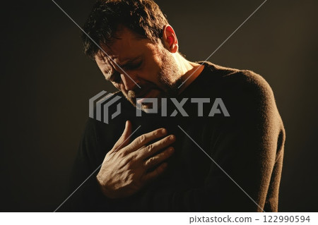 Emotional portrait of a man expressing sorrow and vulnerability 122990594