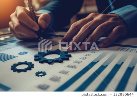Business Professional Analyzing Graphs and Charts with Geared Design Elements and Notepad 122990644