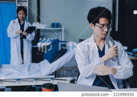 Positive doctor working on laptop in medical office, portrait. 122990950