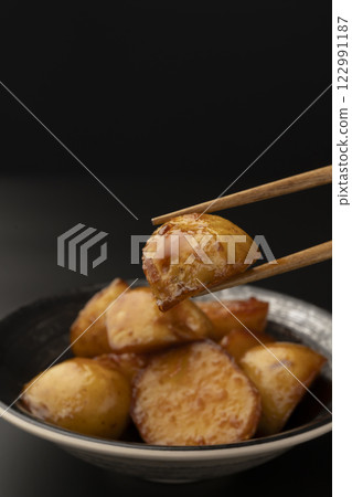 Pick up boiled new potatoes with chopsticks Pick up boiled new potatoes with chopsticks 122991187