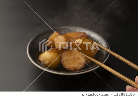 Pick up boiled new potatoes with chopsticks 122991190
