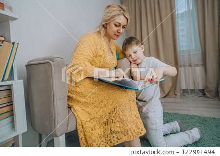 smiling child and adult sharing a book together in a peaceful home setting concept of storytelling, communication, and emotional intelligence smiling child and adult sharing a book together in a peaceful home setting concept of storytelling, communication, and emotional intelligence 122991494