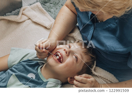boy lying white blanket during speech therapy session with female therapist in cozy room, concept of speech correction, childhood development, and healthcare, close up boy lying white blanket during speech therapy session with female therapist in cozy room, concept of speech correction, childhood development, and healthcare, close up 122991509