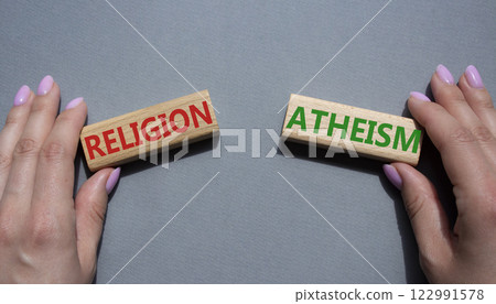 Religion or Atheism symbol. Concept word Religion or Atheism on wooden blocks. Businessman hand. Beautiful grey background. Business and Religion or Atheism concept. Copy space 122991578