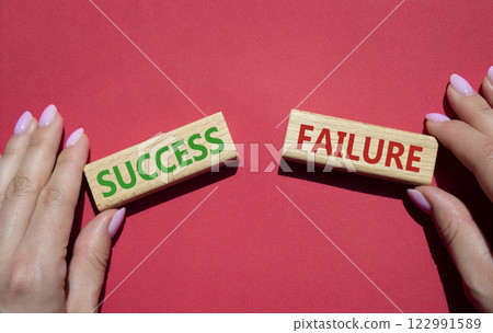 Success or Failure symbol. Concept word Success or Failure on wooden blocks. Businessman hand. Beautiful red background. Business and Success or Failure concept. Copy space 122991589