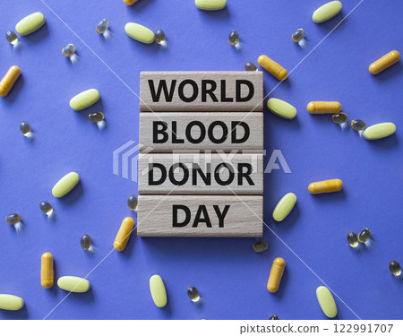 World Blood Donor Day symbol. Concept word World Blood Donor Day on wooden blocks. Beautiful purple background with pills. Medicine and World Blood Donor Day concept. Copy space 122991707