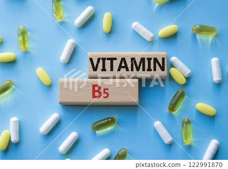 Vitamin B5 symbol. Concept word Vitamin B5 on wooden blocks. Beautiful blue background with pills. Medicine and Vitamin B5 concept. Copy space Vitamin B5 symbol. Concept word Vitamin B5 on wooden blocks. Beautiful blue background with pills. Medicine and Vitamin B5 concept. Copy space 122991870