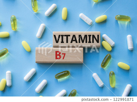 Vitamin B7 symbol. Concept word Vitamin B7 on wooden blocks. Beautiful blue background with pills. Medicine and Vitamin B7 concept. Copy space Vitamin B7 symbol. Concept word Vitamin B7 on wooden blocks. Beautiful blue background with pills. Medicine and Vitamin B7 concept. Copy space 122991871