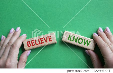 Believe or Know symbol. Concept word Believe or Know on wooden blocks. Businessman hand. Beautiful green background. Business and Believe or Know concept. Copy space 122991881