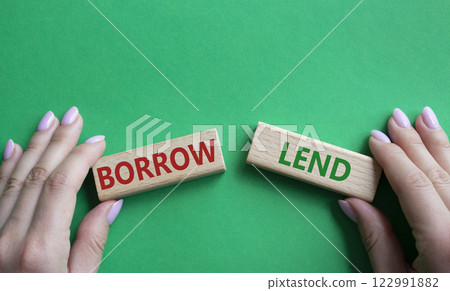 Lend or Borrow symbol. Concept word Lend or Borrow on wooden blocks. Businessman hand. Beautiful green background. Business and Lend or Borrow concept. Copy space 122991882