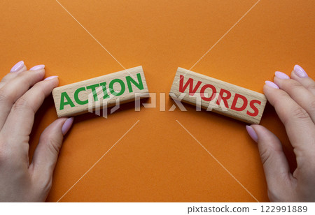 Action or words symbol. Concept word Action or words on wooden blocks. Businessman hand. Beautiful orange background. Business and Action or words concept. Copy space 122991889