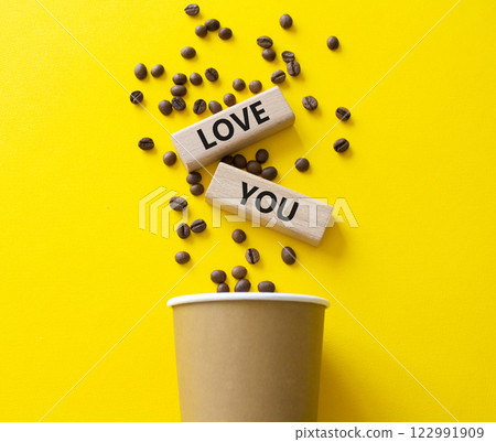 Love you symbol. Concept word Love you on wooden blocks. Beautiful yellow background with coffee cup. Business and Love you concept. Copy space 122991909
