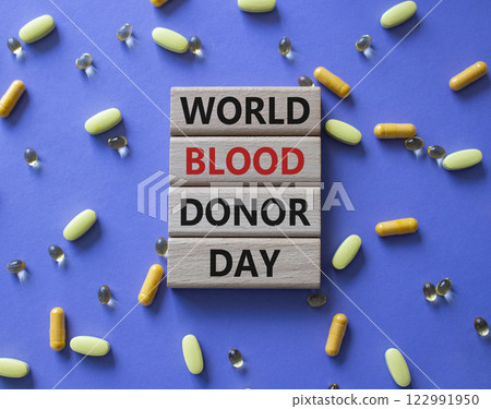 World Blood Donor Day symbol. Concept word World Blood Donor Day on wooden blocks. Beautiful purple background with pills. Medicine and World Blood Donor Day concept. Copy space 122991950