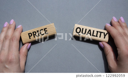Price and Quality symbol. Concept word Price and Quality on wooden blocks. Businessman hand. Beautiful grey background. Business and Price and Quality concept. Copy space Price and Quality symbol. Concept word Price and Quality on wooden blocks. Businessman hand. Beautiful grey background. Business and Price and Quality concept. Copy space 122992059