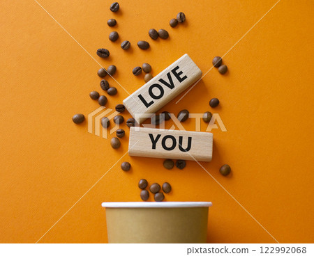 Love you symbol. Concept word Love you on wooden blocks. Beautiful orange background with coffee cup. Business and Love you concept. Copy space Love you symbol. Concept word Love you on wooden blocks. Beautiful orange background with coffee cup. Business and Love you concept. Copy space 122992068
