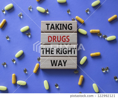 Medicine symbol. Concept word Taking drugs the right way on wooden blocks. Beautiful purple background with pills. Medicine concept. Copy space Medicine symbol. Concept word Taking drugs the right way on wooden blocks. Beautiful purple background with pills. Medicine concept. Copy space 122992121