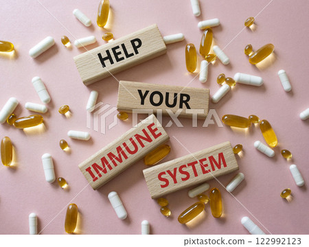 Immune System symbol. Concept word Help Your Immune System on wooden blocks. Beautiful pink background with pills. Medicine and Help Your Immune System concept. Copy space 122992123