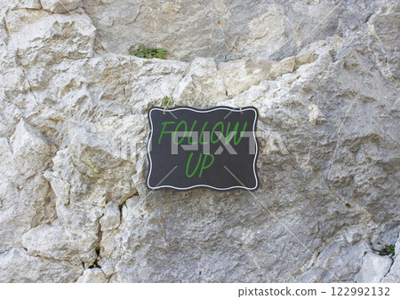 Follow up symbol. Stone wall with words Follow up. Beautiful stone background. Business and Follow up concept. Copy space. 122992132