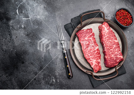 Premium denver, chuck eye steak, beautifully presented, ready for seasoning. A versatile cut ideal for barbecue enthusiasts and steak lovers alike. black background. top view Premium denver, chuck eye steak, beautifully presented, ready for seasoning. A versatile cut ideal for barbecue enthusiasts and steak lovers alike. black background. top view 122992158