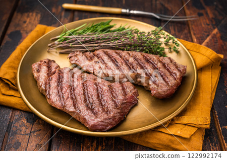 Juicy Denver, chuck eye steak, expertly grilled to perfection, offering a mouthwatering aroma and a deliciously charred exterior. wooden background. top view Juicy Denver, chuck eye steak, expertly grilled to perfection, offering a mouthwatering aroma and a deliciously charred exterior. wooden background. top view 122992174