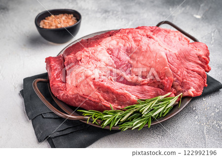 Beautifully arranged raw boneless beef shank pieces on a rustic platter, inviting creativity in the kitchen for delicious slow-cooked meals. grey background. top view Beautifully arranged raw boneless beef shank pieces on a rustic platter, inviting creativity in the kitchen for delicious slow-cooked meals. grey background. top view 122992196