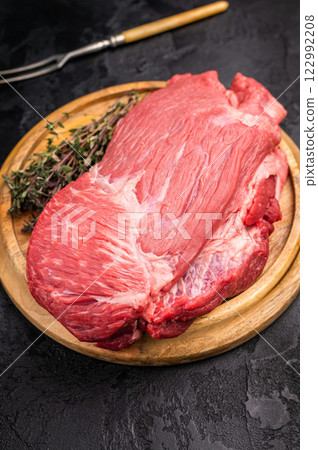 Raw Silverside Round beef meat piece , fresh bottom round on wooden board. black background. Top view Raw Silverside Round beef meat piece , fresh bottom round on wooden board. black background. Top view 122992208