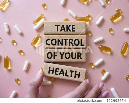 Health symbol. Concept word Take Control of your Health on wooden blocks. Businessman hand. Beautiful pink background with pills. Medicine concept. Copy space 122992354