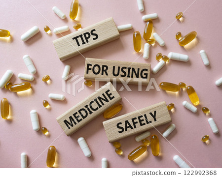Medicine symbol. Concept word Taking drugs the right way on wooden blocks. Beautiful pink background with pills. Medicine concept. Copy space Medicine symbol. Concept word Taking drugs the right way on wooden blocks. Beautiful pink background with pills. Medicine concept. Copy space 122992368
