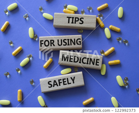 Medicine symbol. Concept word Taking drugs the right way on wooden blocks. Beautiful purple background with pills. Medicine concept. Copy space 122992373