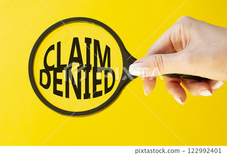 Claim denied symbol. Magnifying Glass with Concept word Claim denied. Beautiful yellow background. Businessman hand. Business and Claim denied concept. Copy space 122992401