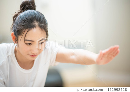 Young woman doing muscle training in indoor gym Young woman doing muscle training in indoor gym 122992528