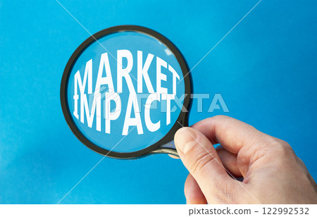 Market impact symbol. Concept word Market impact on magnifying glass. Beautiful blue background. Businessman hand. Business and Market impact concept. Copy space. Market impact symbol. Concept word Market impact on magnifying glass. Beautiful blue background. Businessman hand. Business and Market impact concept. Copy space. 122992532
