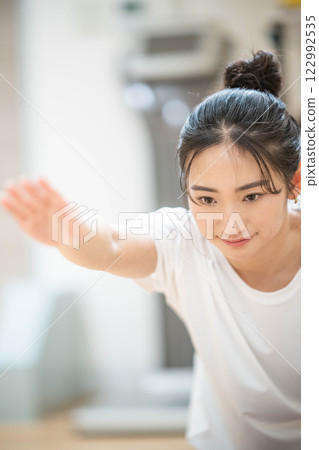 在室內健身房進行肌肉訓練的年輕女子 在室內健身房進行肌肉訓練的年輕女子 122992535