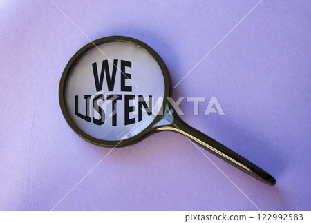 We listen symbol. Concept words We listen on magnifying glass. Beautiful purple background. Business and We listen concept. Copy space. 122992583