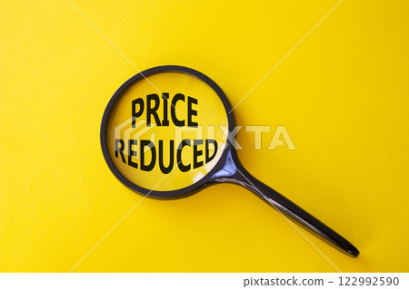 Price reduced symbol. Magnifying Glass with Concept word Price reduced. Beautiful yellow background. Business and Price reduced concept. Copy space 122992590