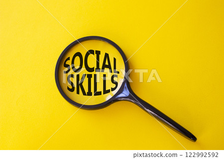 Social skills symbol. Concept words Social skills on magnifying glass. Beautiful yellow background. Business and Social skills concept. Copy space. 122992592