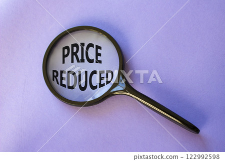 Price reduced symbol. Magnifying Glass with Concept word Price reduced. Beautiful purple background. Business and Price reduced concept. Copy space 122992598