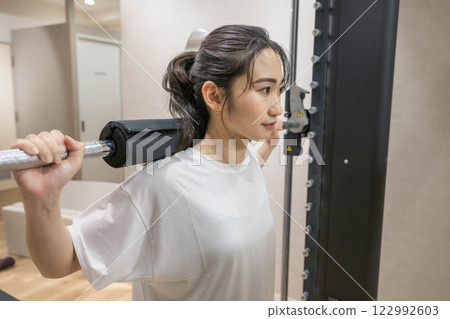 Young woman doing muscle training in indoor gym Young woman doing muscle training in indoor gym 122992603