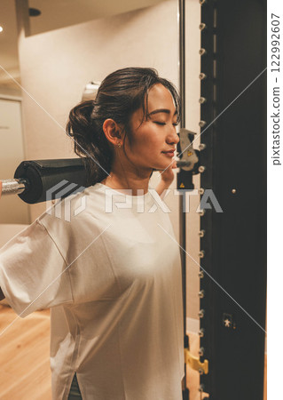 Young woman doing muscle training in indoor gym Young woman doing muscle training in indoor gym 122992607