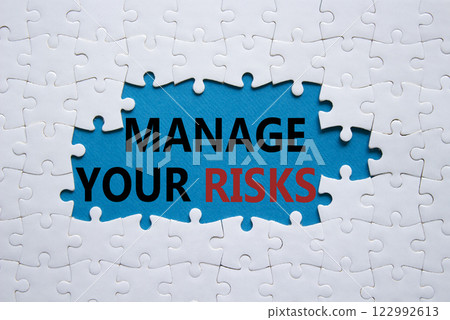 Risks symbol. Concept words Manage your Risks on white puzzle. Beautiful blue background Business and Manage your Risks concept. Copy space. Risks symbol. Concept words Manage your Risks on white puzzle. Beautiful blue background Business and Manage your Risks concept. Copy space. 122992613