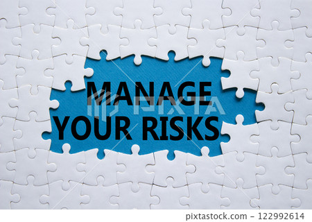 Risks symbol. Concept words Manage your Risks on white puzzle. Beautiful blue background Business and Manage your Risks concept. Copy space. Risks symbol. Concept words Manage your Risks on white puzzle. Beautiful blue background Business and Manage your Risks concept. Copy space. 122992614