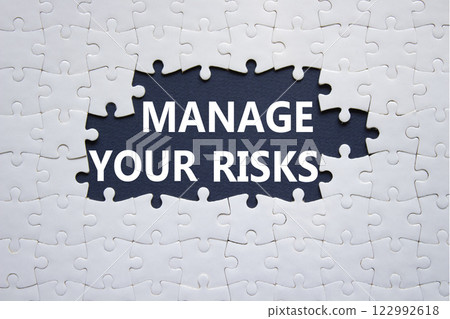 Risks symbol. Concept words Manage your Risks on white puzzle. Beautiful deep blue background Business and Manage your Risks concept. Copy space. Risks symbol. Concept words Manage your Risks on white puzzle. Beautiful deep blue background Business and Manage your Risks concept. Copy space. 122992618