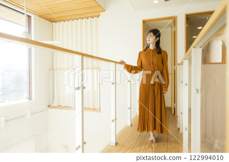 A custom-built house with an open ceiling and a woman A custom-built house with an open ceiling and a woman 122994010