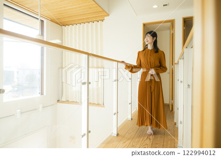 A custom-built house with an open ceiling and a woman A custom-built house with an open ceiling and a woman 122994012