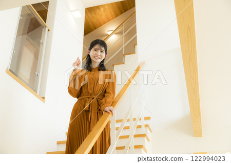 A custom-built house with an open ceiling and a woman 122994023